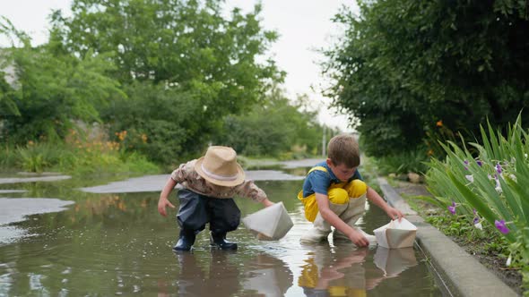 Outdoor Children, Cheerful Kids Male in Rubber Boots Enjoy Spending Time Together on Streets Playing alt