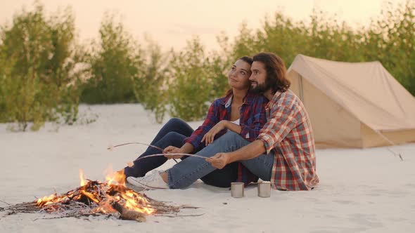 Tourist Couple Camping Near Campfire Outdoors on the Nature alt
