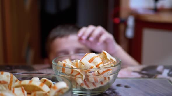 Hungry Teen Steals Chips From Table in a Plate While No One Sees
