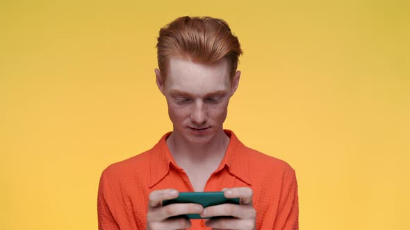 Cheerful Caucasian Man Using Smartphone for Playing Games alt