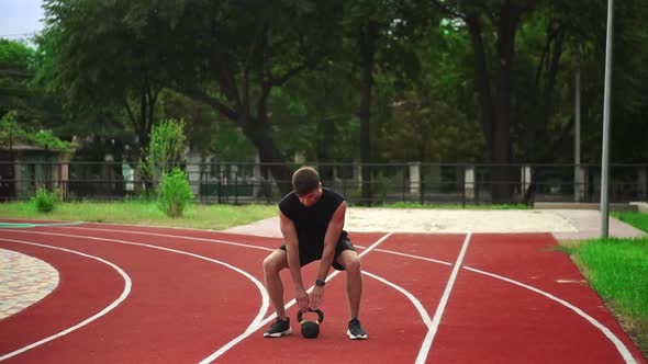 A Man in Black Sportswear with a Beautiful Body Sculpture Trains with Weight alt