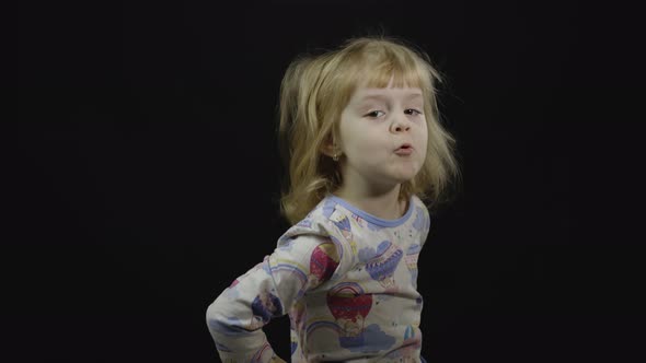 Little Baby Girl in Pajama Is Fooling Around and Make Faces alt