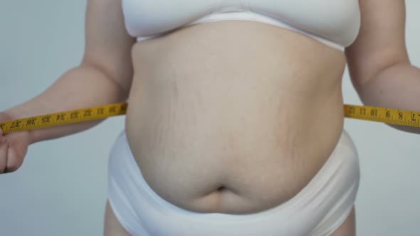 Overweight Female Taking Stomach Measurements, Health, Dieting and Motivation alt
