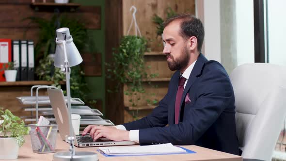 Confident Corporate Manager Typing an Email on the Laptop alt
