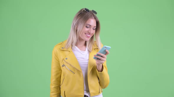 Happy Young Rebellious Blonde Woman Using Phone alt