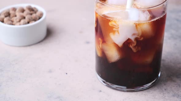 Cooking milk bubble tea with tapioca pearls in glass. alt