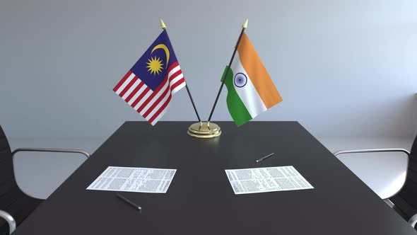 Flags of Malaysia and India and Papers on the Table alt