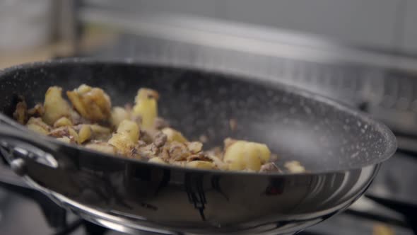 Potatoes and meat cooking slowmotion