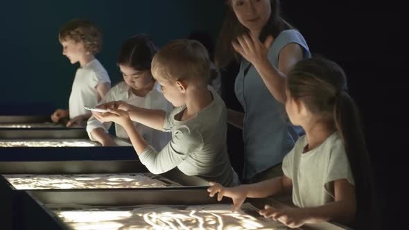 Children Appreciating Sand Drawing Made by Classmate alt