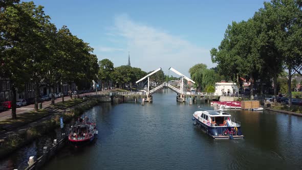 A pleasure boat sails up the Vecht towards a bridge at Weesp in Netherlands alt