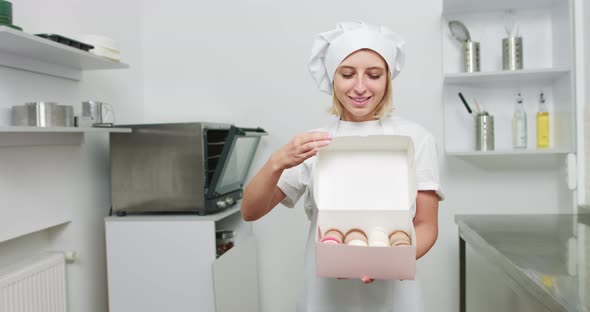 Girl Confectioner In White Hat And Apron Holding Box With Tasty Colorful alt