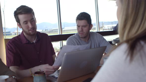 Group of young business people working together in casual workspace