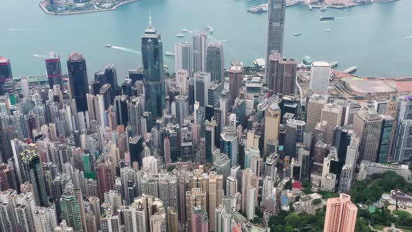 Tilt up aerial view of Victoria Harbour, Hong Kong during the day with beautiful rain clouds. alt