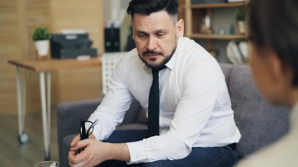 Grieving Young Man Sharing Problems with Female Therapist Crying During Session alt