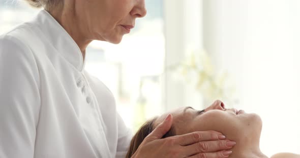 Close up of therapist massaging the head of her patient alt