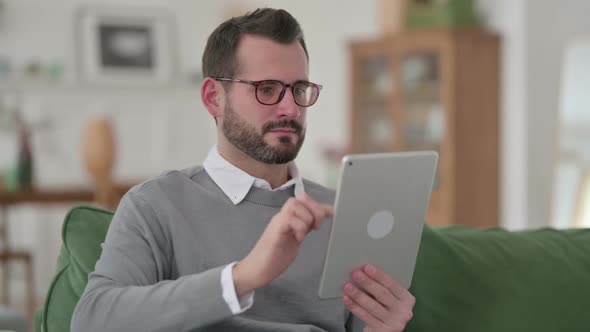 Middle Aged Man Using Digital Tablet at Home alt