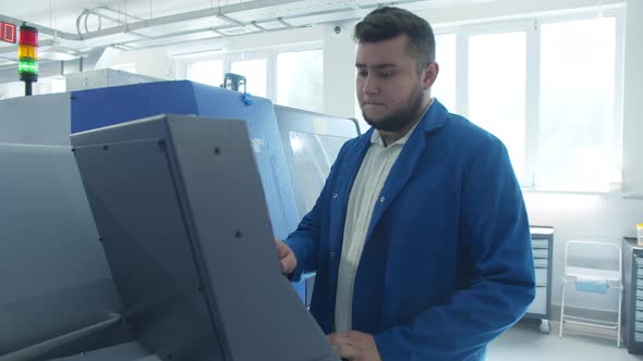 Industrial Factory Technician Operating Machine Near Display