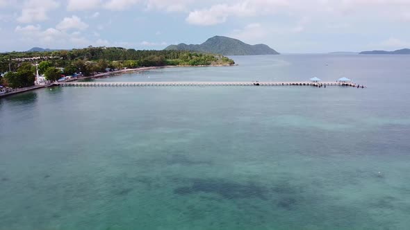 A Long Pier Extending out into Tropical Waters Aerial alt