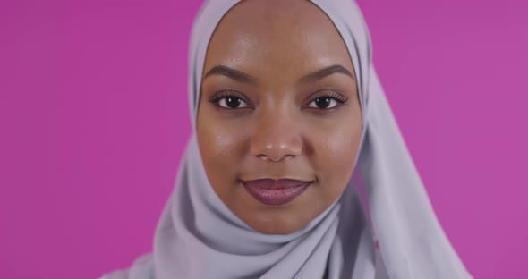 Young Modern Muslim Afro Beauty Wearing Traditional Islamic Clothes Against Plastic Pink Background alt