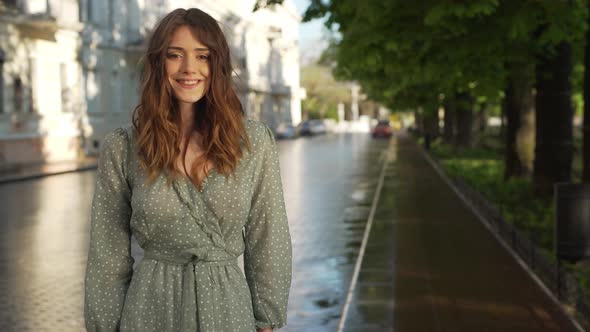 Portrait of Brunette Shy Woman 20s Wearing Beautiful Summer Dress Smiling While Walking Through alt