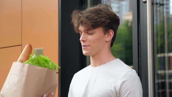 Close Up Food Delivery Woman Courier Deliver Paper Bag of Groceries Smiling Man alt