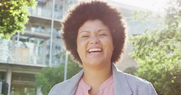 Portrait of happy plus size biracial woman in city alt