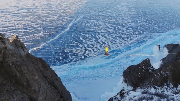 Tightrope Walker on the Background of Blue Ice Frozen Lake.