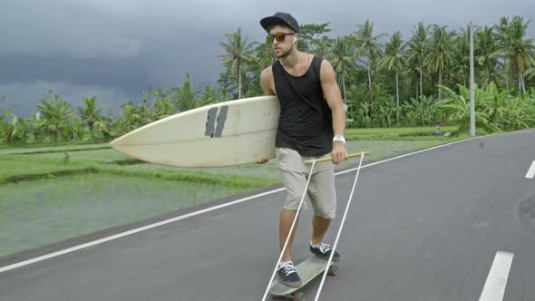 Longboarder Holding Surfboard and Skitching after Scooter alt