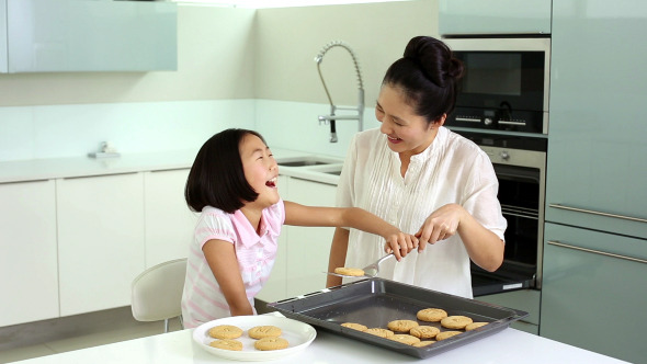 Mother And Daughter Taking Cookies