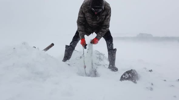 Fisherman Ice Fishing on the Lake alt