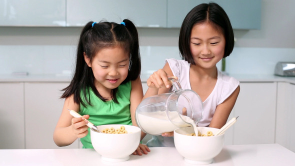 Two Girls Eating Cereal