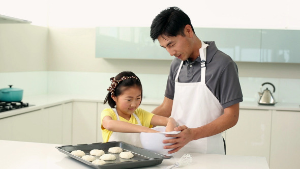 Father And Daughter Making Cookies Together