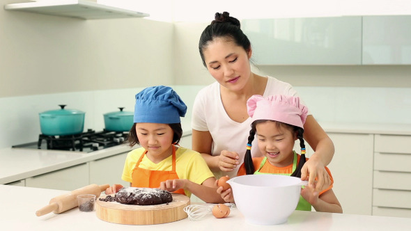 Smiling Mother And Cute Daughters Baking Together