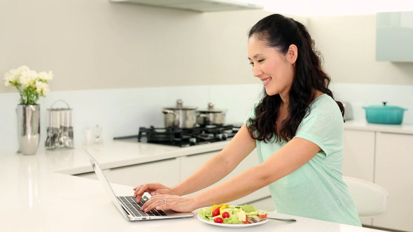 Pretty Woman Using Laptop And Eating Salad