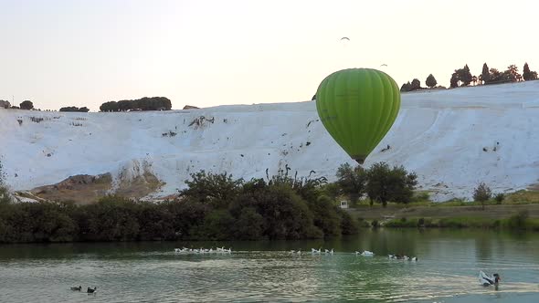 Hot Air Balloons in White Travertines and Lake of Pamukkale, a Touristic Natural World Heritage Site