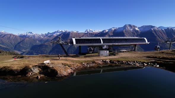 Hiker walking to gondola station in stunning Swiss alpine and lake panorama alt