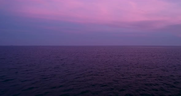 4k drone video flight over ocean, sea at beautiful purple sunset. alt