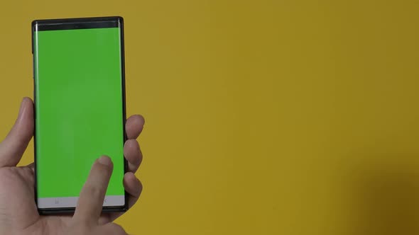 Smartphone screen. Smart phone isolated on color background. Green screen chroma key technique. Man