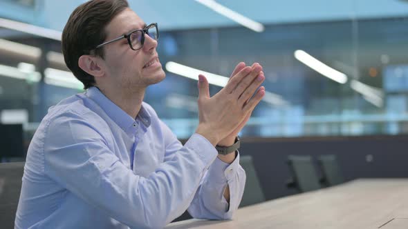 Young Man Feeling Worried While Sitting in Office alt