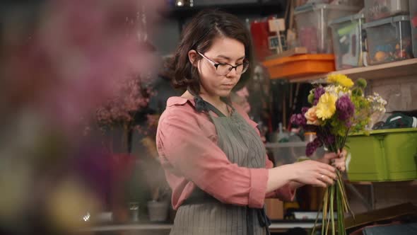 Woman Florist Makes Bouquet of Flowers. Professional Worker Creating Beautiful Floral Composition