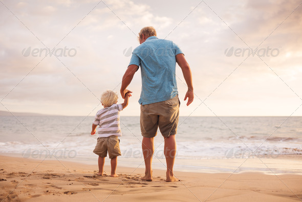 Father and son wallking on the beach - Stock Photo - Images