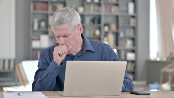 Sick Man Coughing While Working on Laptop in Office alt