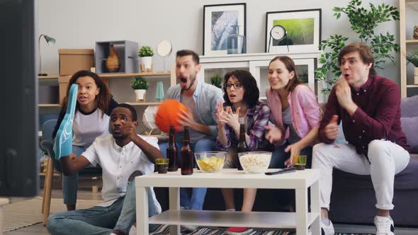Basketball Fans Watching Sports Game on TV at Home Supporting Favorite Team alt