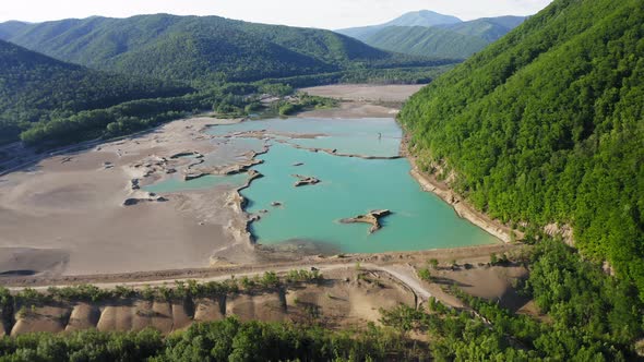 Drone View of a Dam with a Turquoise Lake alt
