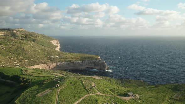 AERIAL: Steep Coastline Shore in Malta with Roaring Blue Mediterranean Sea