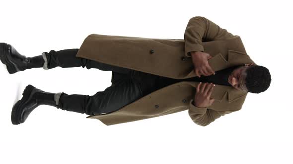 Young Energetic Male Adjusting His Coat and Sorting It Out Vertical White Background alt
