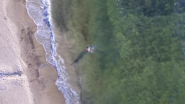 Aerial drone view of a man kiteboarding on a kite board. alt