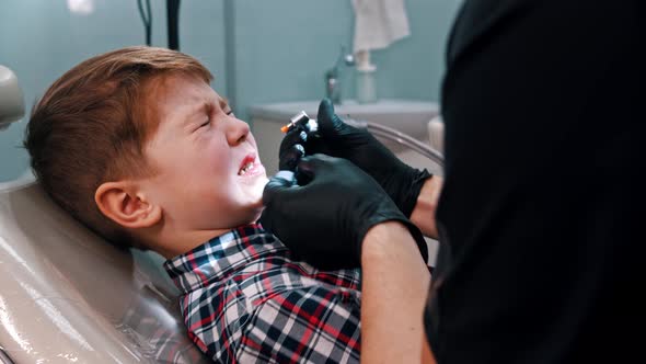A Little Stressful Boy Getting His Teeth Done in the Dentistry alt