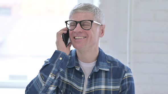 Portrait of Casual Middle Aged Man Talking on Smartphone alt