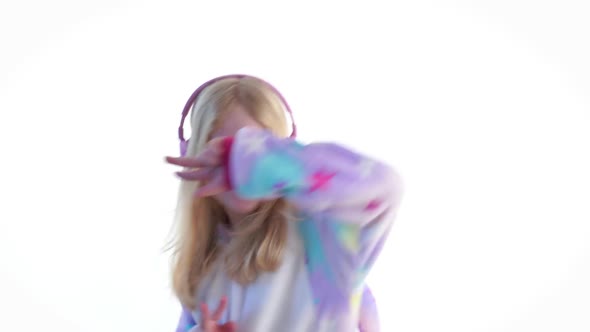 Modern Fashion - Beautiful Blonde Girl Listens To Music with Headphones and Dancing on a White